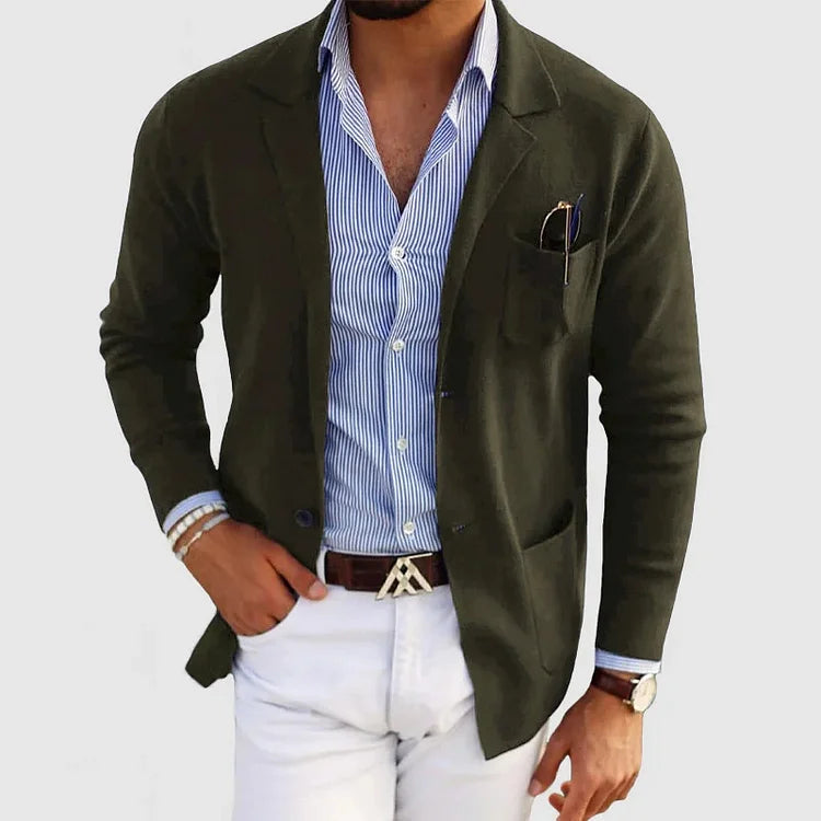 Mann in stilvollem, dunkelgrünem Blazer, gestreiftem Hemd und weißer Hose. Elegante Herrenmode, Business-Look, modische Accessoires.