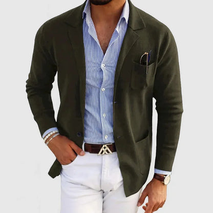 Mann in stilvollem, dunkelgrünem Blazer, gestreiftem Hemd und weißer Hose. Elegante Herrenmode, Business-Look, modische Accessoires.