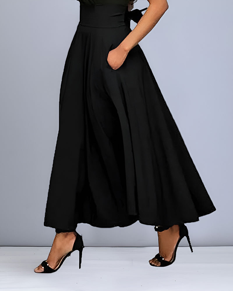 Frau in eleganter, schwarzer, bodenlanger Hose mit weitem Bein und hohen Absätzen. Modetrend, Damenbekleidung, stilvolle Abendmode.