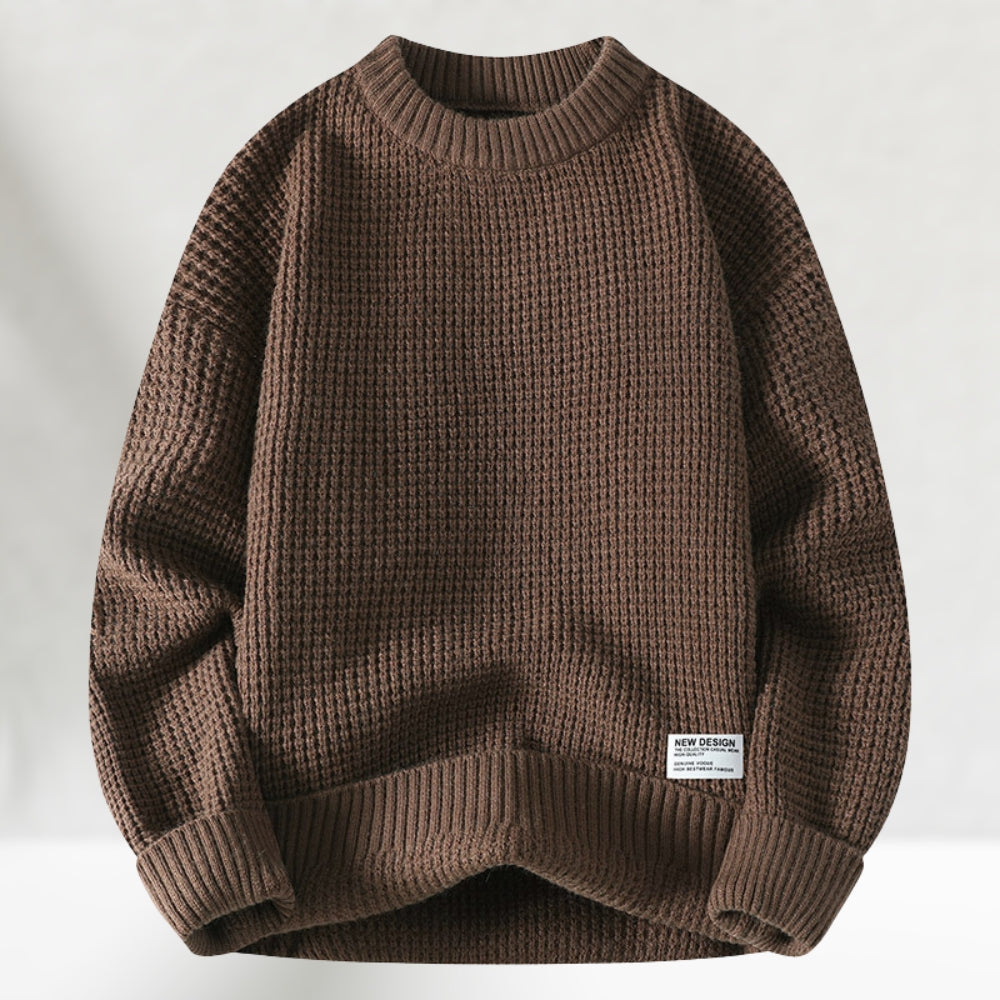 Brauner Strickpullover aus Wolle, grobmaschig, mit Rundhalsausschnitt und Etikett. Modischer Herrenpullover für Herbst und Winter.