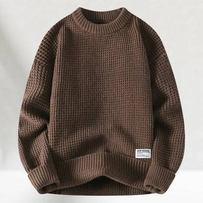 Brauner Strickpullover aus Wolle, grobmaschig, mit Rundhalsausschnitt und Etikett. Modischer Herrenpullover für Herbst und Winter.