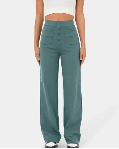 Frau in grüner, hoch taillierter, weiter Hose mit Knöpfen und Taschen, trägt weißes Crop-Top. Modetrend, Damenbekleidung, stilvolle Hose.