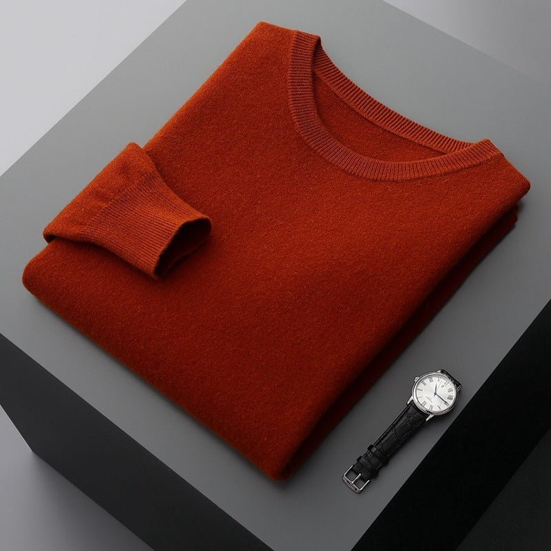 Roter Pullover aus Kaschmir auf grauem Tisch, daneben eine elegante Armbanduhr. Hochwertige Mode, luxuriöse Materialien, stilvolle Accessoires.