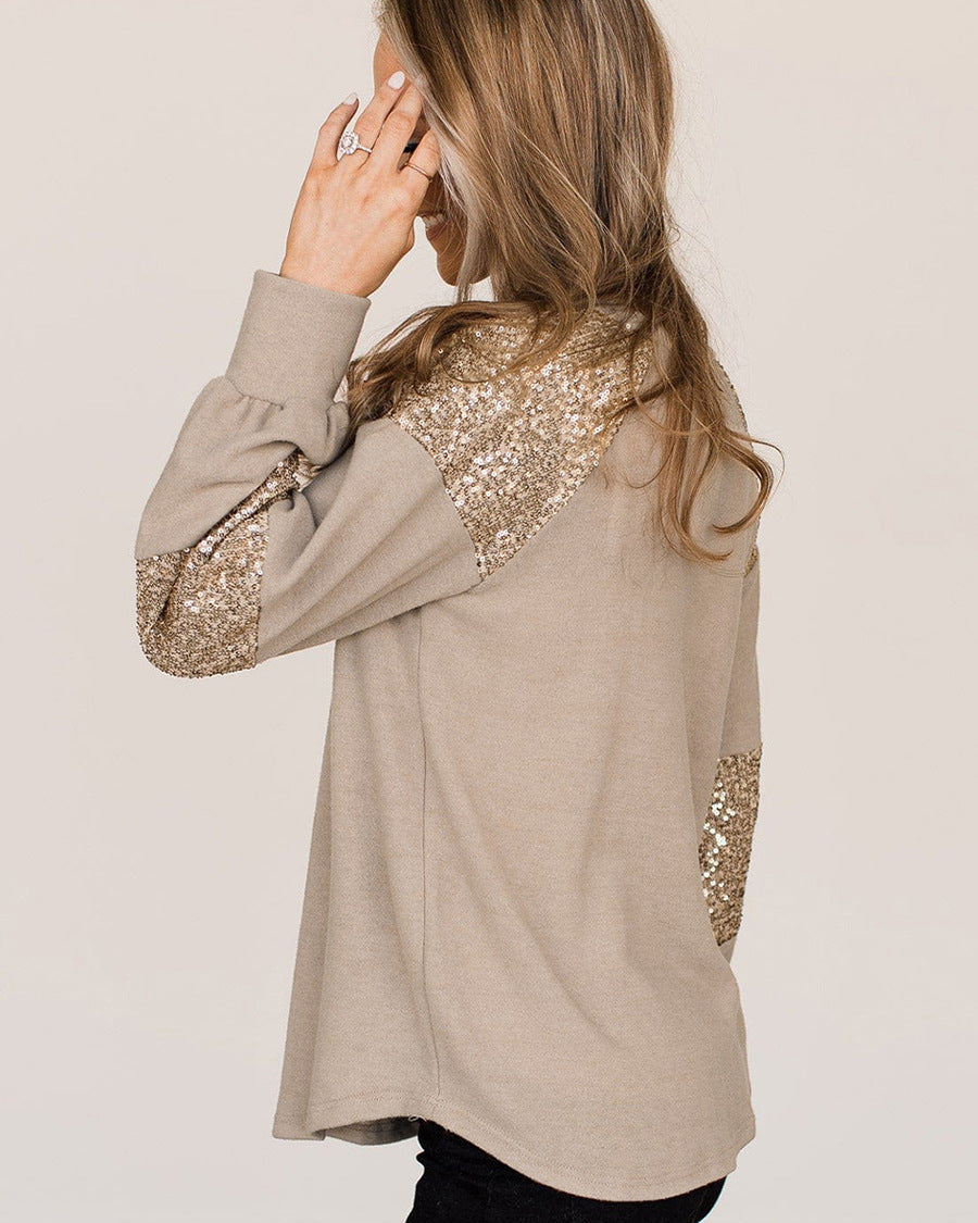 Frau trägt beige Pullover mit goldenen Pailletten-Ärmeln, seitliche Ansicht. Modetrend, eleganter Damenpullover, stilvolle Freizeitkleidung.