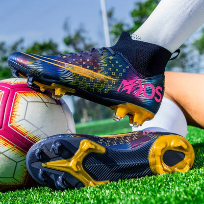 Fußballschuhe mit buntem Design und goldenen Stollen auf grünem Rasen, neben einem Fußball. Perfekt für Fußballtraining und Wettkampf.