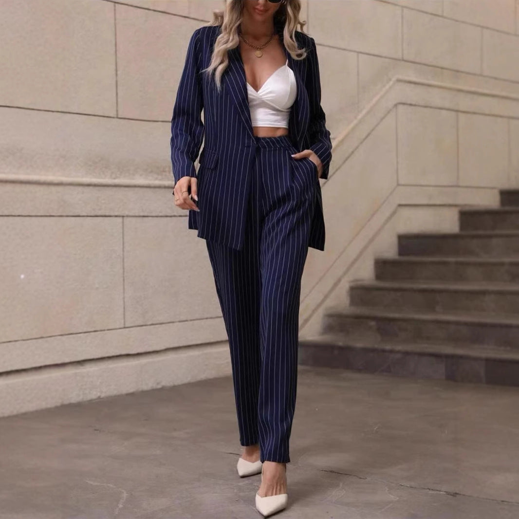 Frau in gestreiftem Anzug und weißem Top, elegante Mode, Business-Look, moderne Kleidung, Treppe im Hintergrund, stilvolle Schuhe.