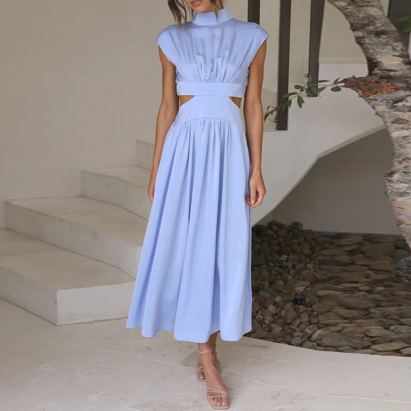 Frau in hellblauem, ärmellosem Kleid mit Cut-Outs, steht auf Treppe. Elegantes Sommeroutfit, Mode, Damenbekleidung, stilvoll, modern.