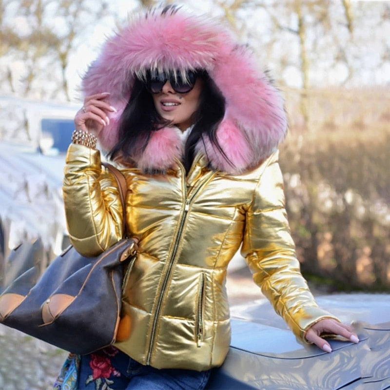 Frau in goldener Daunenjacke mit rosa Fellkapuze, Sonnenbrille und großer Tasche. Wintermode, stilvolle Outdoor-Bekleidung, modische Damenjacke.