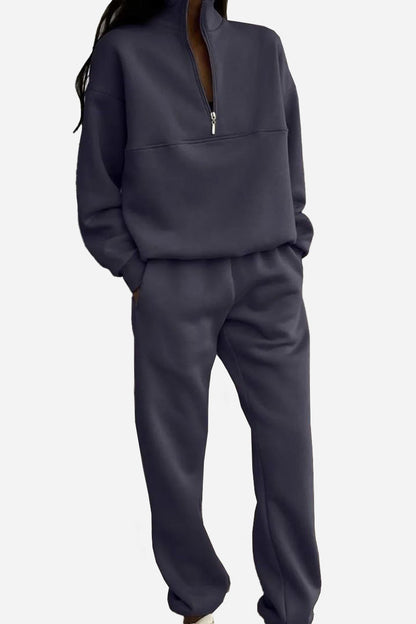 Dunkelgrauer Damen-Jogginganzug mit Reißverschluss, lässig und bequem, ideal für Freizeit und Sport. Modischer Zweiteiler für Damen.