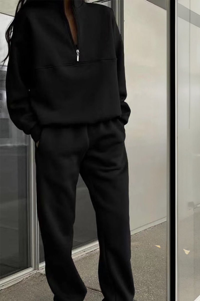 Schwarzer Jogginganzug für Damen, bestehend aus langärmligem Oberteil mit Reißverschluss und passender Hose, ideal für Freizeit und Sport.