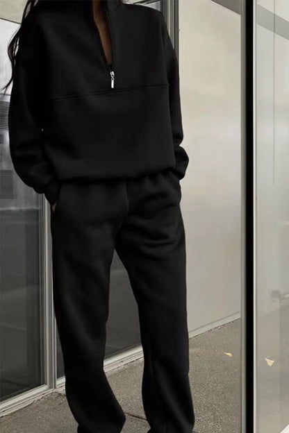 Schwarzer Jogginganzug für Damen, bestehend aus langärmligem Oberteil mit Reißverschluss und passender Hose, ideal für Freizeit und Sport.