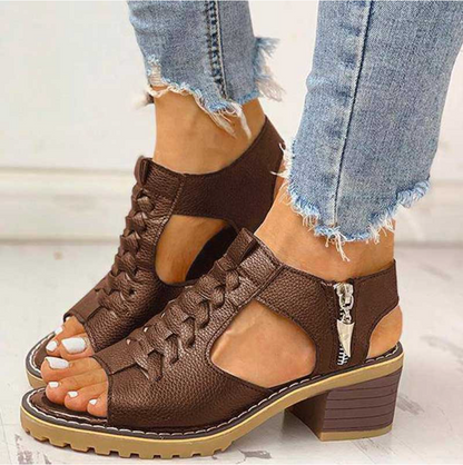Braune Leder-Sandalen mit Blockabsatz und seitlichem Reißverschluss, getragen mit ausgefransten Jeans. Modische Damenschuhe für Sommer.