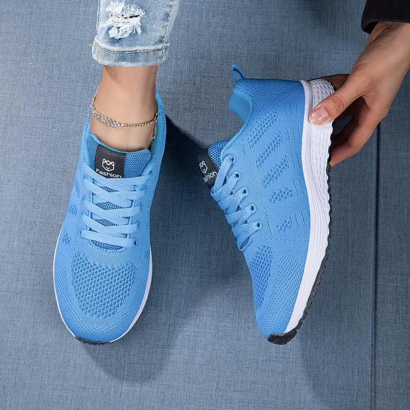 Blaue Sportschuhe auf Jeansstoff, moderne Sneaker mit weißer Sohle, Damenmode, Freizeitlook, bequeme Laufschuhe, trendige Fußbekleidung.