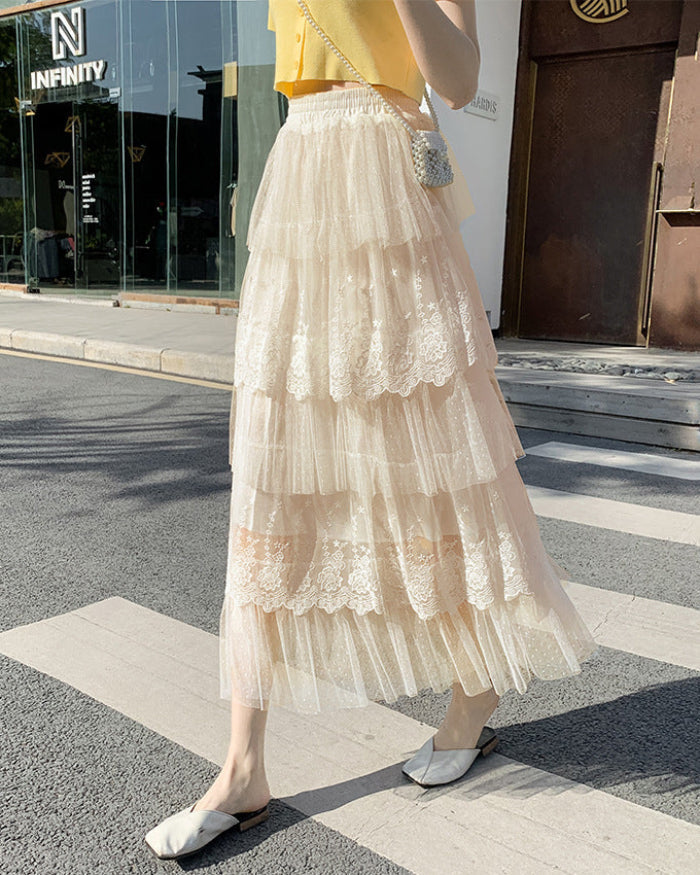 Frau in gelbem Oberteil und langem, mehrlagigem Tüllrock mit Spitze, überquert Straße. Sommermode, eleganter Stil, Stadtbummel.