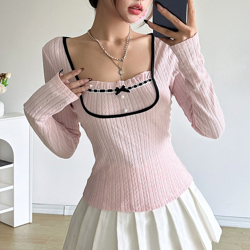 Frau in rosa Strickpullover mit schwarzem Rand und weißem Rock, hält Smartphone. Mode, Damenbekleidung, trendiger Look, Innenraum.