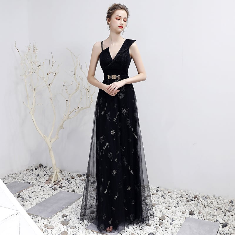 Elegantes schwarzes Abendkleid mit V-Ausschnitt und Gürtel, verziert mit Sternenmustern, getragen von einer Frau in einem minimalistischen Raum.