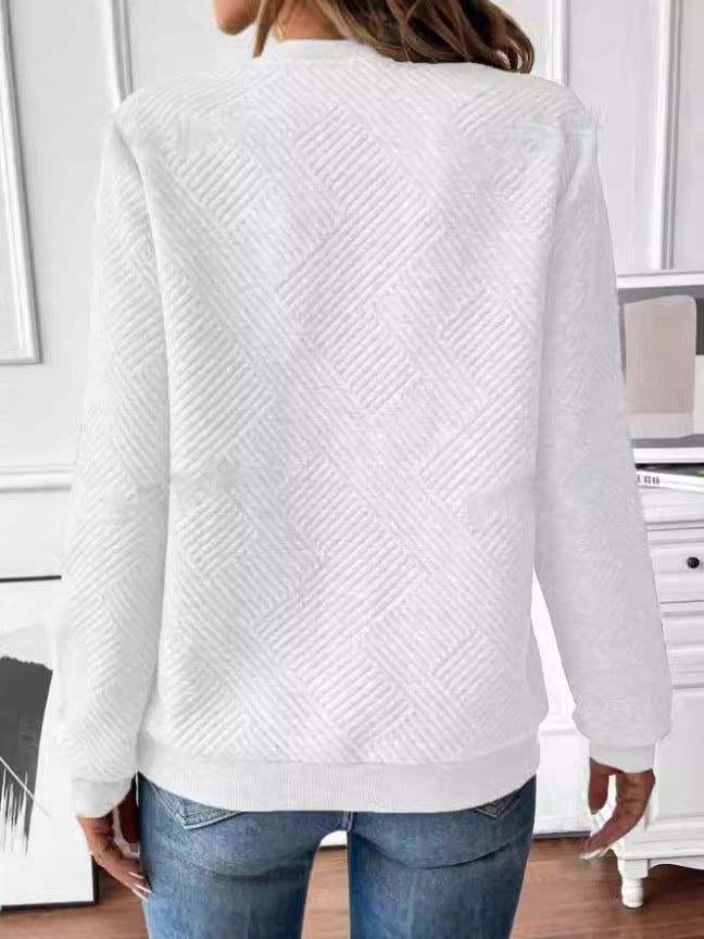 Frau in weißem, strukturiertem Pullover und blauer Jeans von hinten, modernes Wohnzimmer, stilvolle Freizeitmode, Texturdetails, Innenraum.