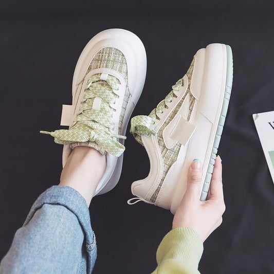 Person trägt modische grüne und weiße Sneaker mit Jeans. Trendige Freizeitschuhe, stilvolles Design, bequeme Passform. Ideal für Streetwear-Look.