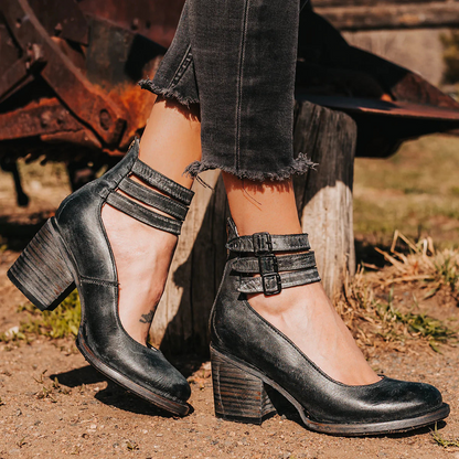 Damenstiefeletten mit Blockabsatz, schwarzes Leder, doppelte Knöchelriemen, modisch, robust, ideal für Herbstmode, Outdoor-Hintergrund.