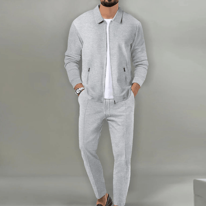Grauer Herrenanzug mit Reißverschlussjacke und Hose, getragen von einem Mann. Stilvolle Herrenmode, Freizeitanzug, modernes Design.