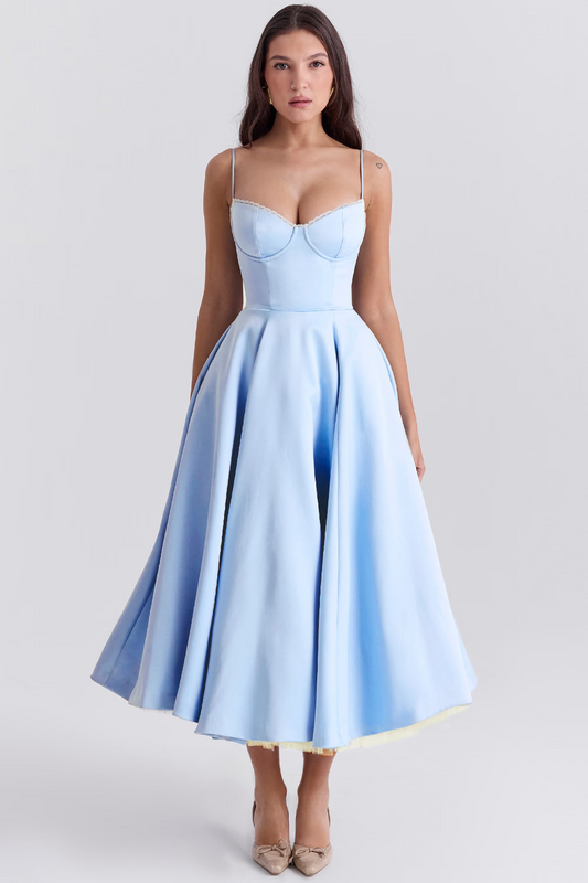 Frau in elegantem, hellblauem Abendkleid mit Spaghettiträgern und weitem Rock, stehend vor neutralem Hintergrund. Mode, Abendgarderobe, Damenkleidung.