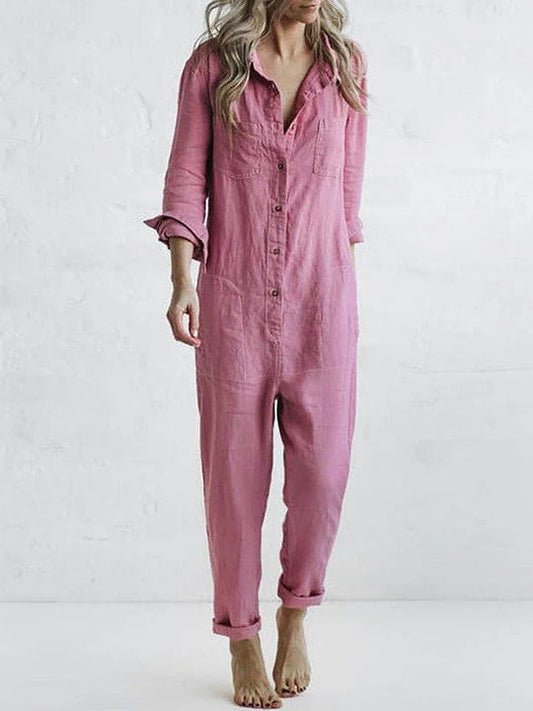 Frau in rosa Leinen-Jumpsuit, langärmelig, mit Knopfleiste, lässiger Stil, barfuß, vor weißem Hintergrund. Modetrend, Damenbekleidung.