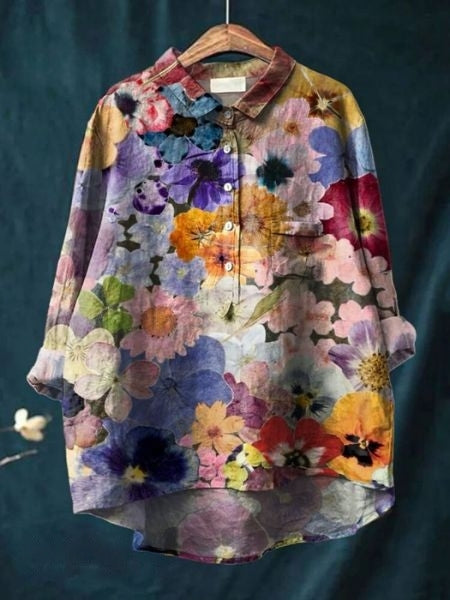 Bunte Damenbluse mit Blumenmuster auf Kleiderbügel, langärmlig, Knopfleiste, lebendige Farben, modisch, ideal für Frühling und Sommer.