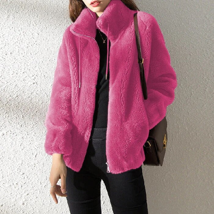 Frau in pinker Kunstpelzjacke, schwarze Kleidung, braune Tasche, modisch, Wintermode, stilvoll, warm, trendige Damenbekleidung.