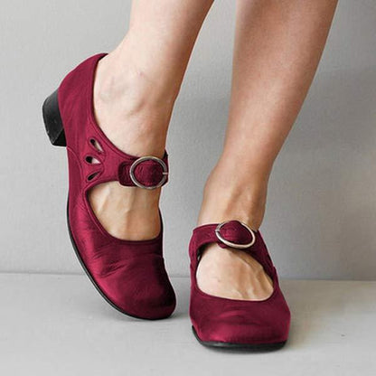 Rote Mary Jane Schuhe mit niedrigem Absatz und Schnallenverschluss, getragen von einer Person. Bequem, modisch, ideal für Alltag und Büro.