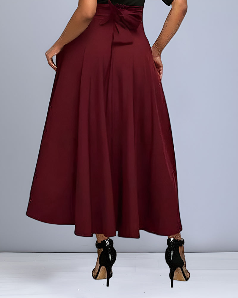 Rückansicht einer Frau in einem eleganten, weinroten Maxirock und schwarzen High Heels. Modische Damenbekleidung, stilvoller Look.