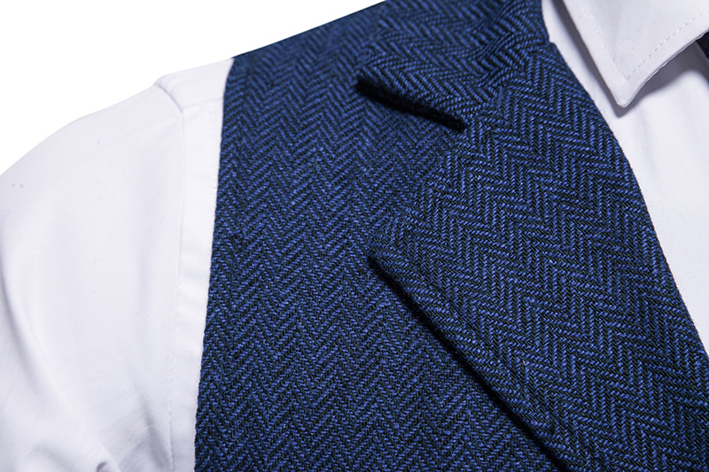 Nahaufnahme eines eleganten blauen Fischgrätenmusters auf einer Weste, kombiniert mit einem weißen Hemd. Herrenmode, stilvolle Kleidung, formelle Bekleidung.
