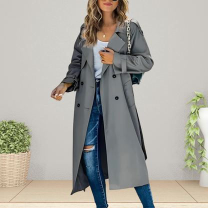 Frau in grauem Trenchcoat, zerrissene Jeans, weißes Top, mit Handtasche. Modetrend Herbst, stilvolle Damenbekleidung, lässiger Look.
