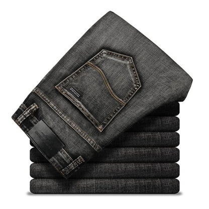 Gestapelte schwarze Jeans mit sichtbarer Gesäßtasche und Etikett, modisch und robust, ideal für Herrenmode und Freizeitkleidung.