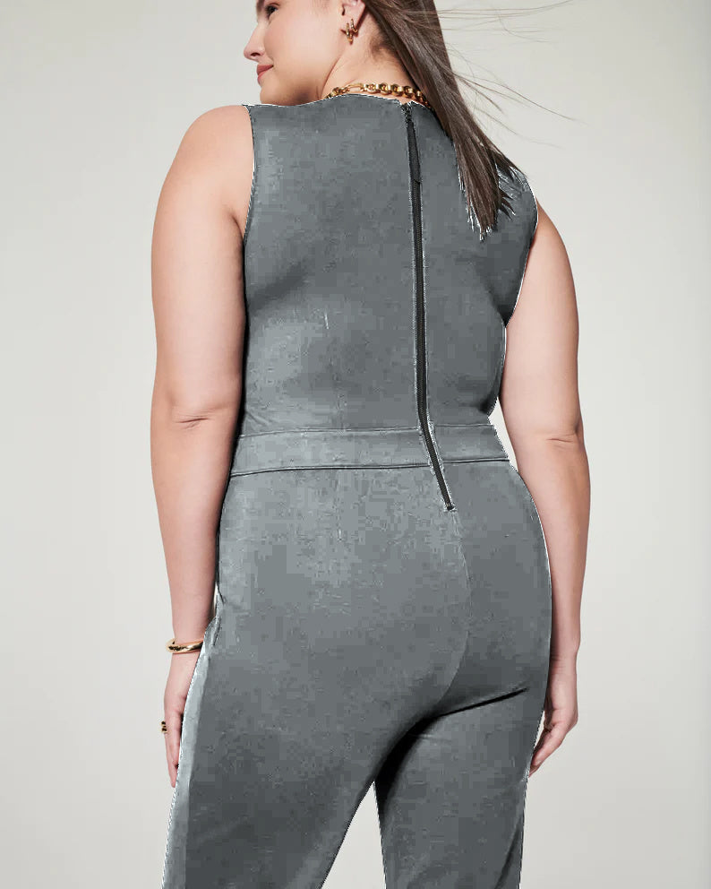 Frau in grauem ärmellosen Jumpsuit mit Reißverschluss hinten, seitlich fotografiert. Mode, Damenbekleidung, eleganter Look.
