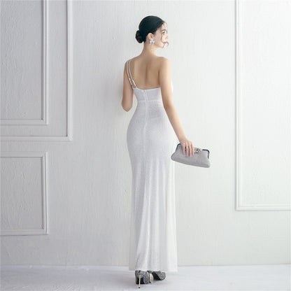 Frau in elegantem, weißem Abendkleid mit Pailletten, hält silberne Clutch. Perfekt für Gala, Hochzeit oder Abendveranstaltung. Eleganz, Mode, Abendgarderobe.