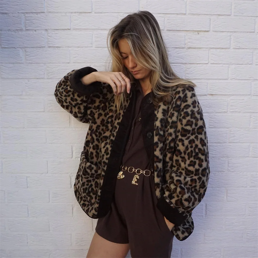 Frau in Leopardenmuster-Jacke vor weißer Ziegelwand, modisches Outfit, trendige Damenmode, Herbstlook, stilvolle Kleidung, lässiger Chic.