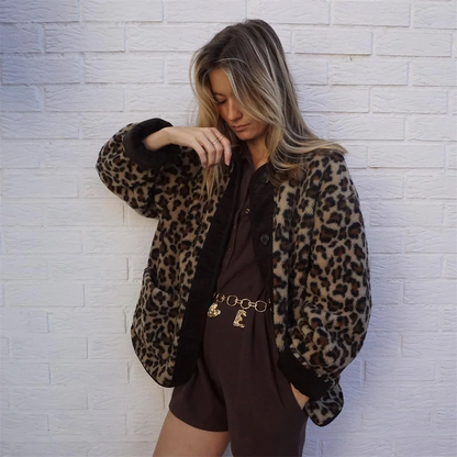 Frau in Leopardenmuster-Jacke vor weißer Ziegelwand, modisches Outfit, trendige Damenmode, Herbstlook, stilvolle Kleidung, lässiger Chic.