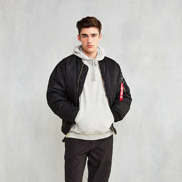 Junger Mann in schwarzer Bomberjacke und grauem Hoodie, lässiger Streetwear-Look, Mode für Herren, trendige Freizeitkleidung, urbaner Stil.