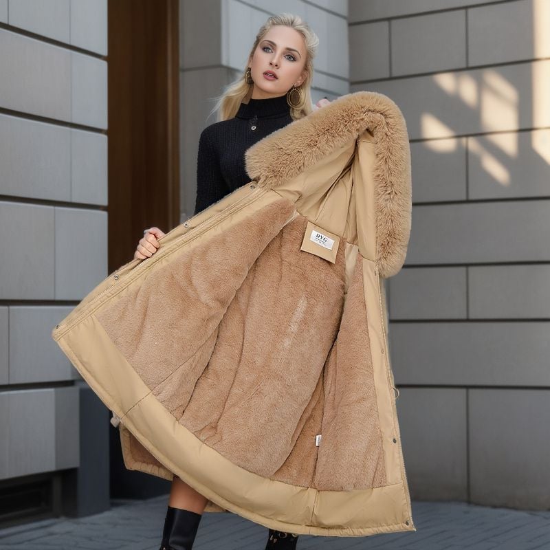 Frau präsentiert eleganten, beigen Wintermantel mit Kunstfellfutter und Kapuze, ideal für kalte Tage. Modetrend, Damenbekleidung, Wintermode.