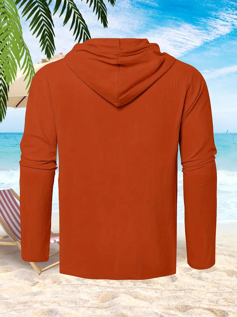 Roter Kapuzenpullover am Strand, Palmen und Liegestuhl im Hintergrund, ideal für Sommermode und Freizeitkleidung.