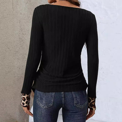 Frau in schwarzem, geripptem Langarmshirt mit Leopardenmuster an den Ärmeln, kombiniert mit blauer Jeans, Rückansicht. Modetrend, Damenbekleidung.