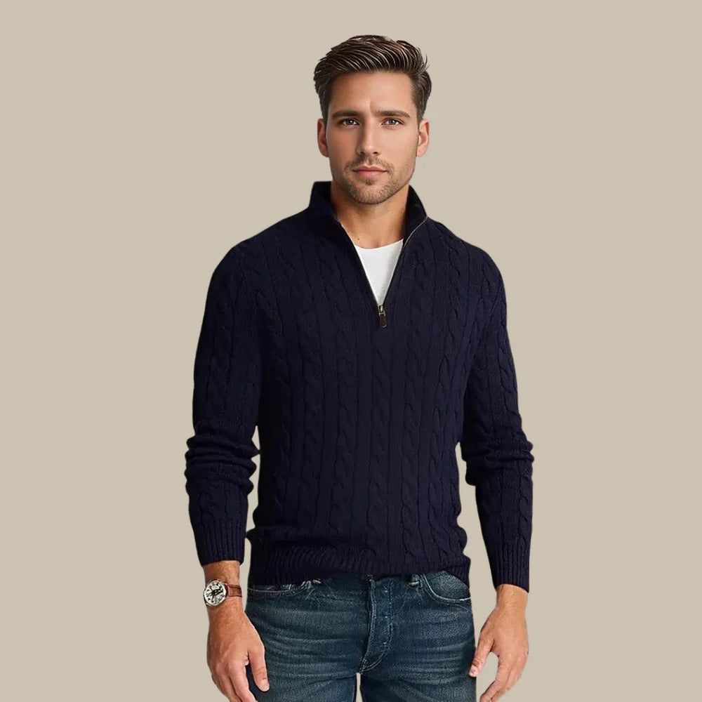 Ein Mann trägt einen dunkelblauen Strickpullover mit Reißverschluss und Jeans vor neutralem Hintergrund. Herrenmode, eleganter Freizeitlook.