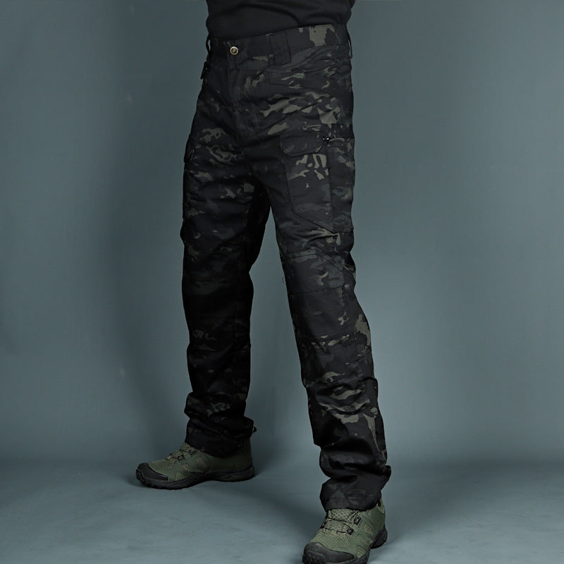 Schwarze taktische Tarnhose, getragen von einer Person, kombiniert mit olivgrünen Stiefeln. Ideal für Outdoor-Aktivitäten und Militärbekleidung.