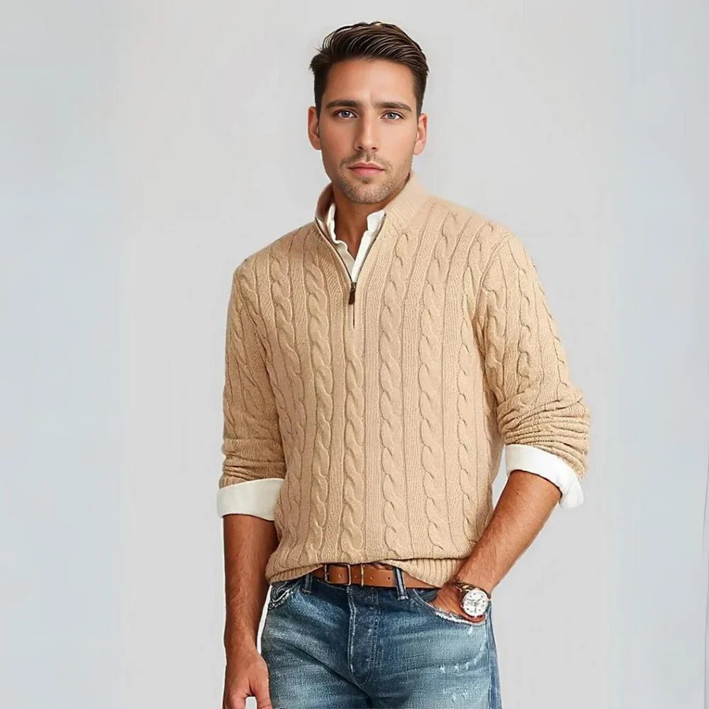 Ein Mann trägt einen beigen Strickpullover mit Zopfmuster und blaue Jeans. Mode, Herrenbekleidung, stilvoller Look, Freizeitoutfit.