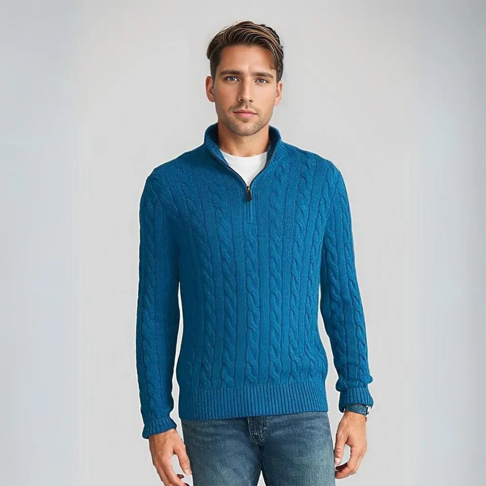 Ein Mann trägt einen blauen Strickpullover mit Zopfmuster und Reißverschluss, kombiniert mit Jeans. Mode, Herrenbekleidung, Strickpullover.