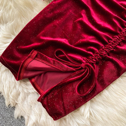 Rotes Samtkleid mit Glitzer, gerafftem Detail und Schleife auf weißem Fellteppich. Elegantes Abendkleid, luxuriöses Design, festliche Mode.