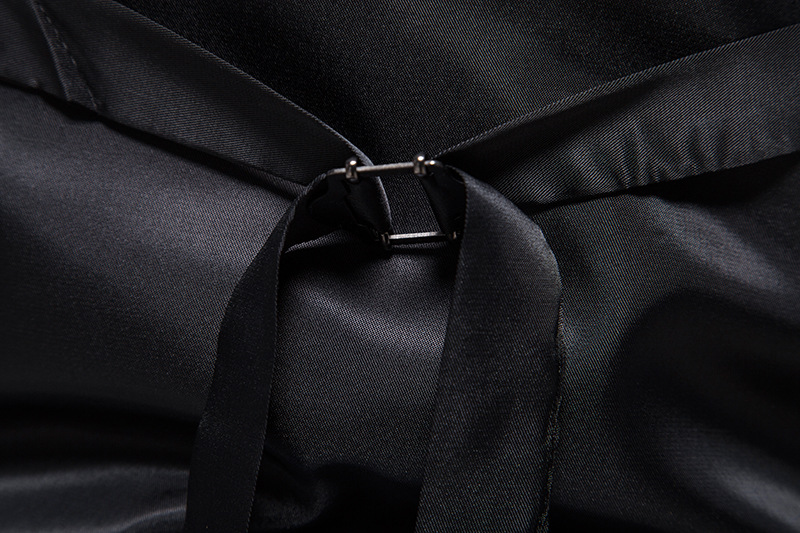 Schwarzes Satinkleid mit Schleife und Metallverschluss, elegante Abendmode, luxuriöser Stoff, Detailansicht, hochwertige Verarbeitung.