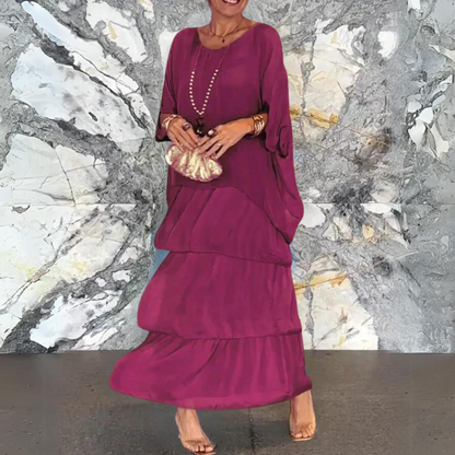 Elegante Frau in langem, fliederfarbenem Kleid vor marmorierter Wand. Mode, Abendkleid, Stil, Accessoires, Trend.
