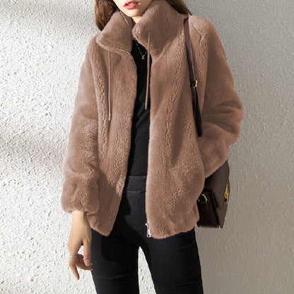 Damenmode: Frau trägt stilvolle, beige Kunstpelzjacke mit Reißverschluss. Trendige Winterbekleidung, warm und elegant für kalte Tage.