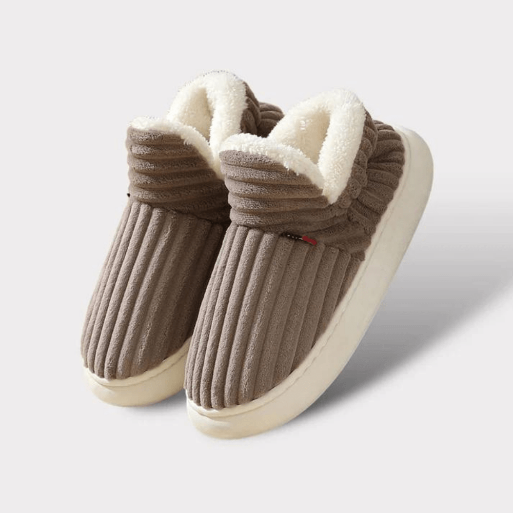 Braune, gestreifte Hausschuhe mit weißem Futter auf weißem Hintergrund. Bequeme, warme Pantoffeln für den Winter. Ideal für Zuhause.